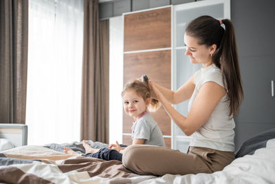 Side view of mother and daughter at home