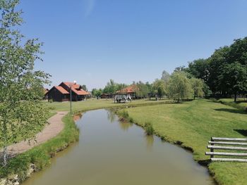 Scenic view of lake amidst houses and trees against sky