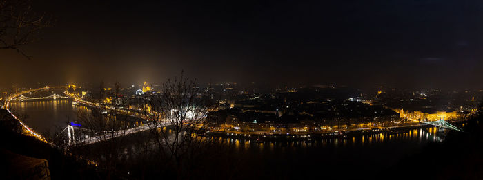 High angle view of illuminated city by river at night