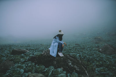 Rear view of woman standing on rock