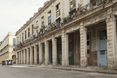 Street by buildings against sky in city