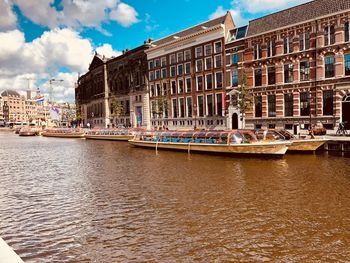 Boats in canal amidst buildings in city