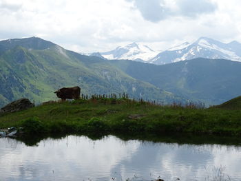 Scenic view of lake and mountains against sky