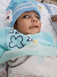 Portrait of cute baby lying on bed