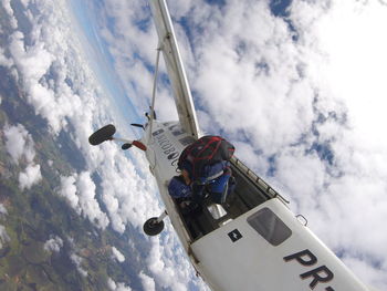 Low angle view of men flying against sky