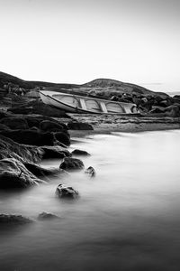 Scenic view of rocky shore against sky