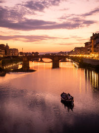 Bridge over river against sky during sunset