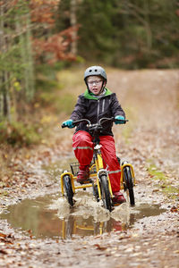 Boy cycling through forest