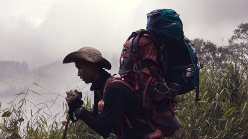 Men standing by plants on land