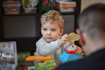 Little boy plays with father in the children's room and looks out the window