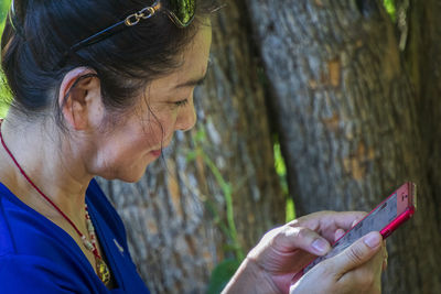 Close-up of woman using smart phone outdoors