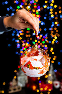 Cropped hand of woman holding christmas decoration