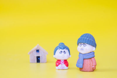 Close-up of figurine toy against yellow wall