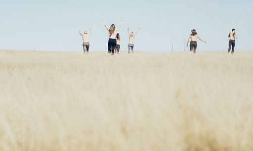 People standing on field against sky