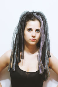 Portrait of young woman with hairstyle against white background