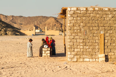 Men standing on stone wall in desert