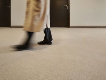 Low section of woman standing on floor in building