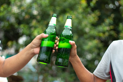 Cropped image of hand holding beer bottle