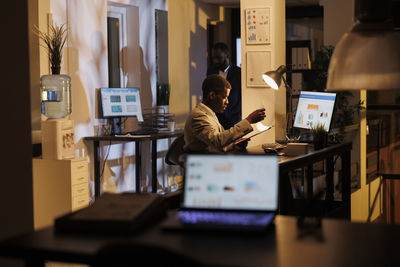 Man using laptop at desk in office