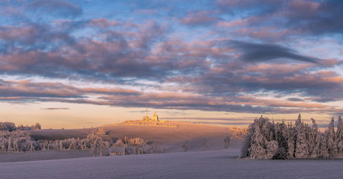 Scenic view of snow field against sky during sunset