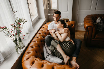 Rear view of couple sitting at home