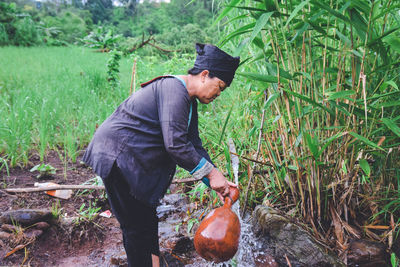 Side view of man holding food on field