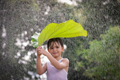 Portrait of smiling young woman in rain