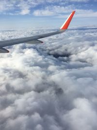 Airplane flying over clouds in sky