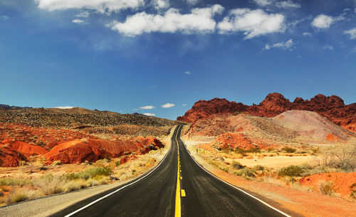 Road by mountain against sky