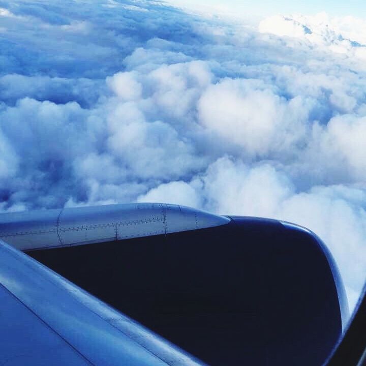 CROPPED IMAGE OF AIRPLANE WING OVER SEA