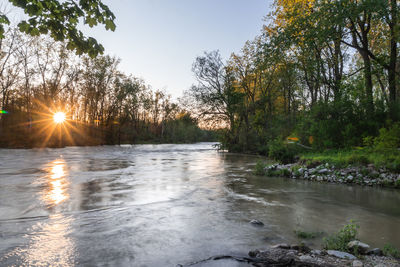 Scenic view of river against sky at sunset