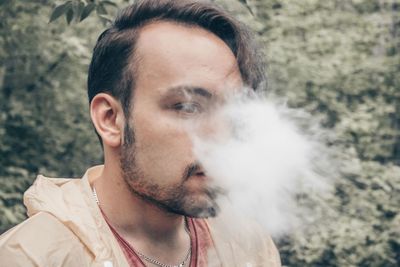 Close-up of young man smoking outdoors