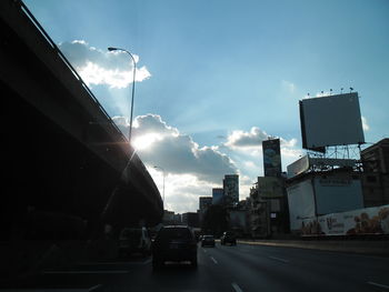 Cars on road in city against sky