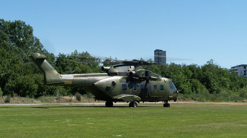 Helicopter on field against clear blue sky