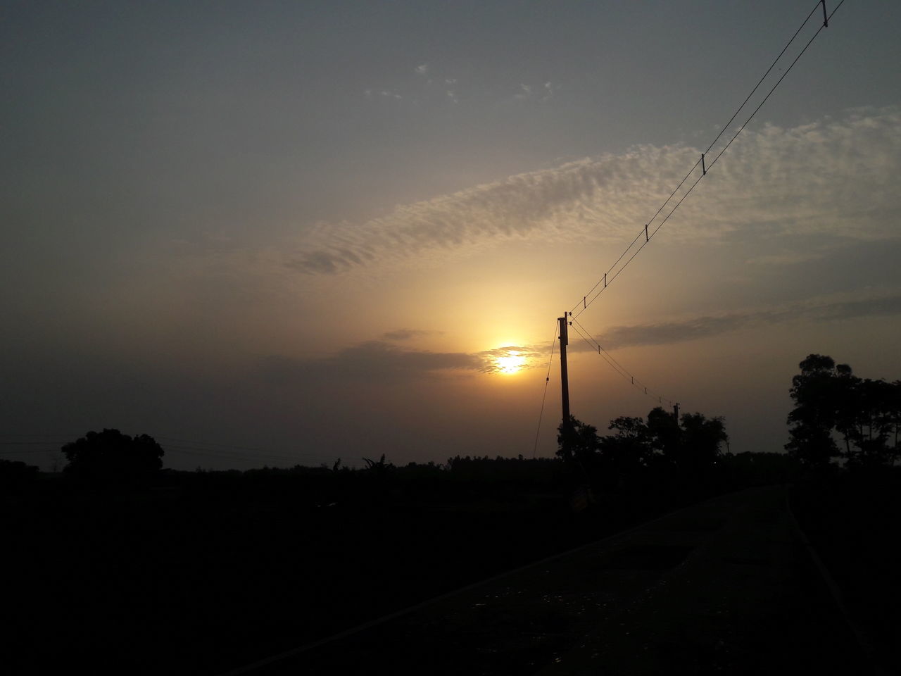 sky, sunset, nature, silhouette, cloud, dawn, transportation, road, tree, beauty in nature, horizon, no people, environment, electricity, scenics - nature, technology, sun, tranquility, landscape, cable, plant, evening, outdoors, light, tranquil scene, street, sunlight, afterglow, electricity pylon, darkness, orange color, land, city