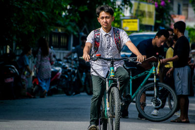 Portrait of people riding bicycle on road