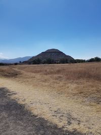 Scenic view of arid landscape against clear blue sky