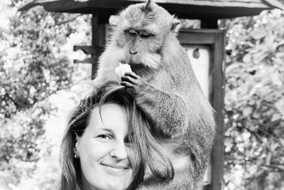 Portrait of woman with monkey sitting on head