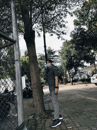 Man standing by tree against plants