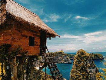 House amidst sea and buildings against sky