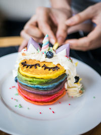 Close-up of hand holding cake on table