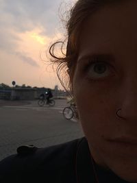 Close-up portrait of woman against sky during sunset