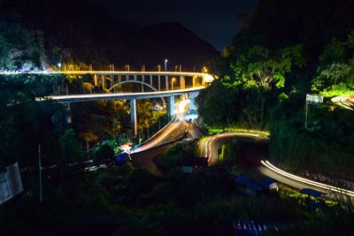 High angle view of footbridge along trees at night