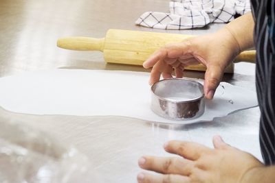 Fat woman hand is stamping round stainless block to cook dim-sum appetizer in kitchen