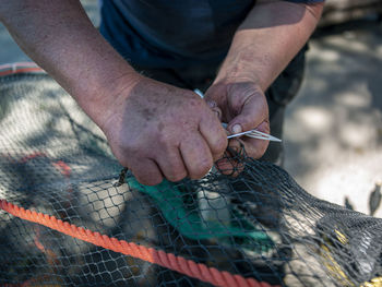 Close-up of man working with fishing net