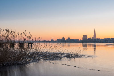 View of city at waterfront during sunset