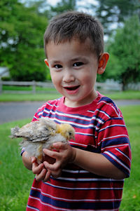 Portrait of cute boy holding bird