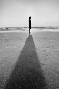 Full length of man standing on beach against sky