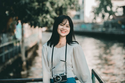 Portrait of smiling young woman standing outdoors