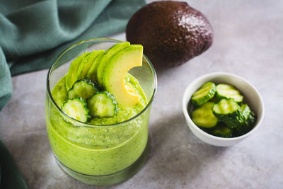 Healthy drink from cucumbers and avocados in a glass on the table